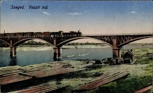 Ak Segedin Szeged Ungarn, Vasuti hid, Eisenbahnbrücke, Holzstämme am Ufer