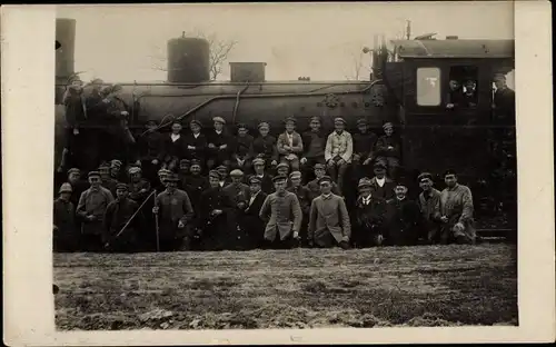 Foto Ak Eisenbahn, Dampflokomotive, Soldaten und Bahnarbeiter in Uniform, Gruppenbild