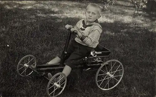 Foto Ak Kinderportrait, Junge im Matrosenhemd, Kinderfahrzeug