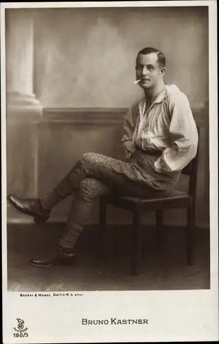 Ak Schauspieler Bruno Kastner, Portrait auf Stuhl sitzend mit Zigarette
