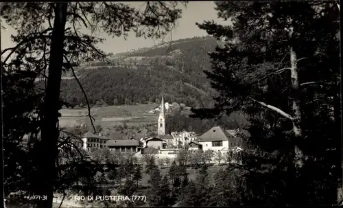 Ak Rio di Pusteria Südtirol, Blick durch die Bäume zum Ort