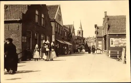 Ak Volendam Nordholland Niederlande, Straßenpartie, Frauen in Tracht, Art Store, Kirchturm