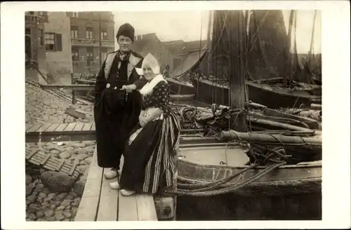 Ak Volendam Nordholland Niederlande, Frau und Mann am Hafen, Niederländische Trachten