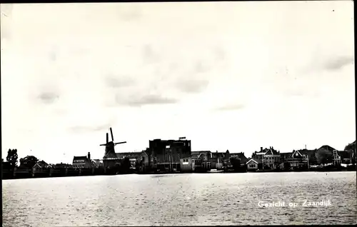 Ak Zaandijk Nordholland, Blick über das Wasser zum Ort, Windmühle