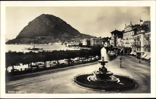 Ak Lugano Kanton Tessin Schweiz, Straßenpartie mit Brunnen, Berg