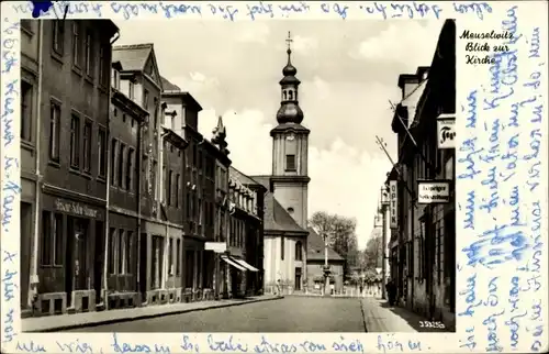 Ak Meuselwitz in Thüringen, Straßenpartie mit Geschäften, Blick zur Kirche