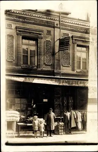 Foto Ak Frankreich, Mann mit Kindern vor einem amerikanischen Geschäft