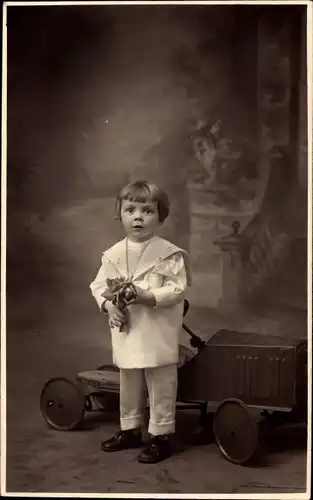 Foto Ak Kleines Kind mit Tretauto