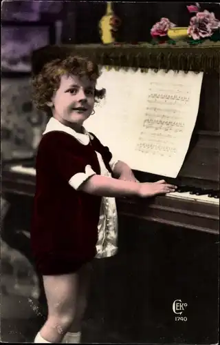 Ak Kleines Kind steht vor einem Klavier