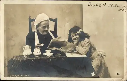 Foto Ak Großmutter liest Zeitung, Enkelin möchte Zuckerstück haben