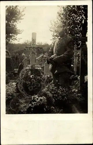 Foto Ak Deutscher Soldat in Uniform an einem Soldatengrab, Obergefreiter Ziegeltrum