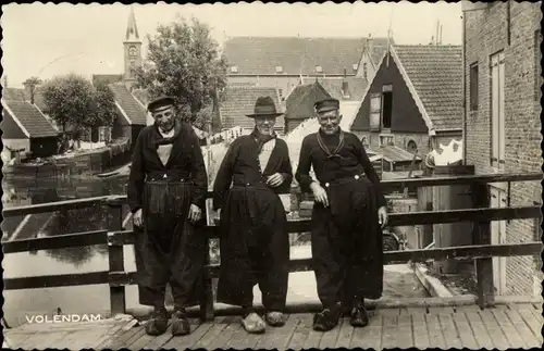 Ak Volendam Nordholland Niederlande, drei Männer in Tracht auf der Brücke stehend