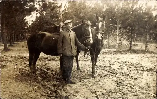Foto Ak Mann in Uniform, Zwei Pferde, Zaumzeug