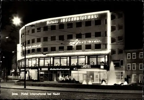 Ak Jena, Hotel International bei Nacht, Leuchtreklame