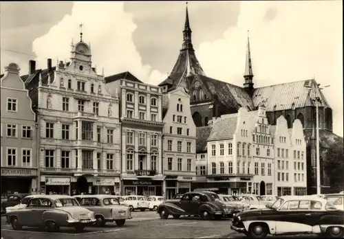 Ak Hansestadt Rostock, Thälmannplatz mit Marienkirche, Geschäft Bücherstube, Autos