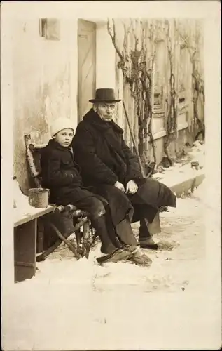 Foto Ak Mann und Kind in Pantoffeln vor einem Haus, Winter