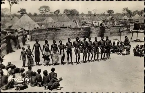 Ak Tanzende Afrikaner, Afrikanisches Dorf, Wohnhäuser, Strohdächer