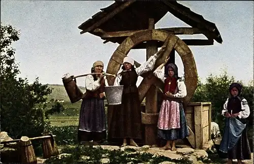 Ak Balkan, Bäuerinnen am Dorfbrunnen, Holzrad, Eimer, Trachten