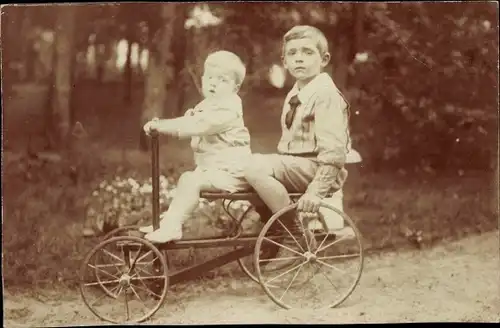Foto Ak Zwei Jungen auf einem Kinderfahrzeug