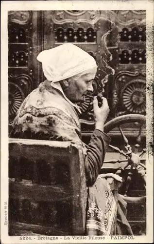 Ak Paimpol Côtes d’Armor, Bretagne, La Vieille Fileuse, Frau in Tracht am Spinnrad mit Pfeife