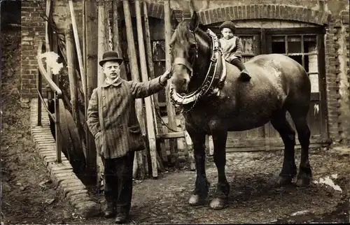 Foto Ak Kleines Kind auf einem Zugpferd sitzend, Mann