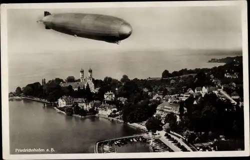 Ak Friedrichshafen am Bodensee, Luftschiff LZ 127 Graf Zeppelin über der Stadt, Fliegeraufnahme