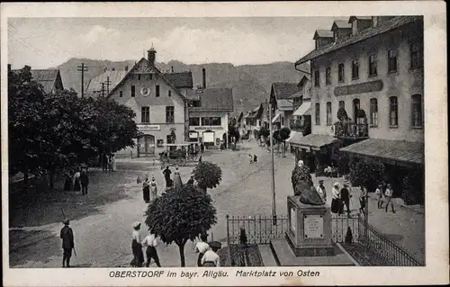 Ak Oberstdorf im Oberallgäu, Marktplatz, Ostansicht, Löwendenkmal, Passanten, Ansichtskartengeschäft