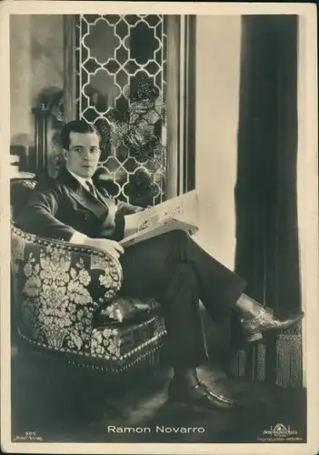Ak Schauspieler Ramon Novarro, Portrait, sitzt im Sessel