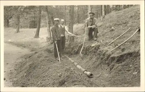Foto Ak Bad Harzburg am Harz, Männer verlegen Rohrleitungen, Straßenpartie im Wald