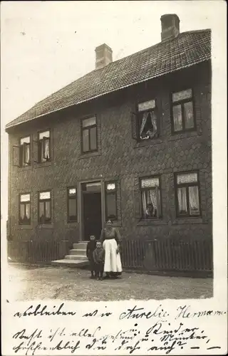 Foto Ak Langelsheim Harz, Frau mit Kindern vor einem Wohnhaus