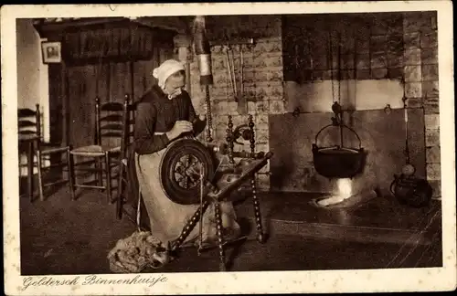 Ak Gelderland Niederlande, Bauernstube, Niederländische Tracht, Frau beim Spinnen