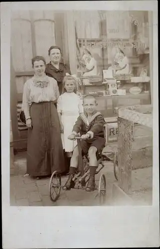 Foto Ak Frauen und Kinder in einem Haarschneide Salon, Junge mit Dreirad