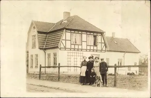 Foto Ak Pinneberg in Holstein, Familie vor einem Wohnhaus, Hund