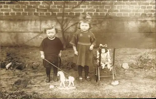 Foto Ak Mädchen mit Puppe im Puppenwagen, Junge mit Holzpferd