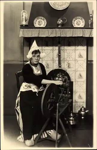 Foto Ak Niederländisches Bauernhaus, Wohnstube, Frau am Spinnrad