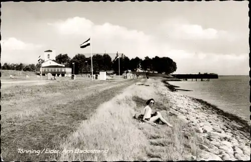 Ak Tönning an der Eider Nordfriesland, Badestrand, Flaggen, Frau sitzend im Gras