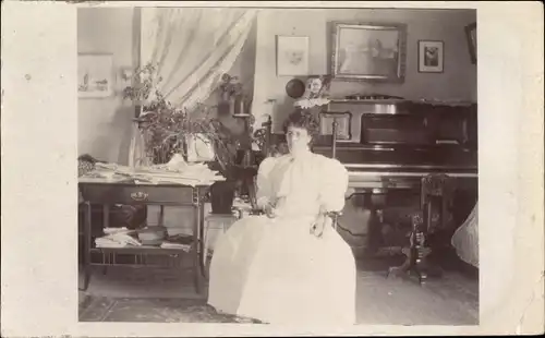 Foto Ak Frau in weißem Kleid, Wohnzimmer, Klavier, Tisch