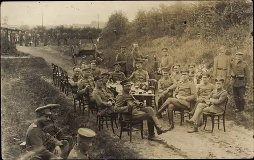 Foto Ak Deutsche Soldaten in Uniformen an einem Tisch im Freien, I WK