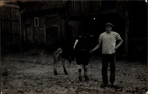 Foto Ak Mann mit Rind vor einem Haus