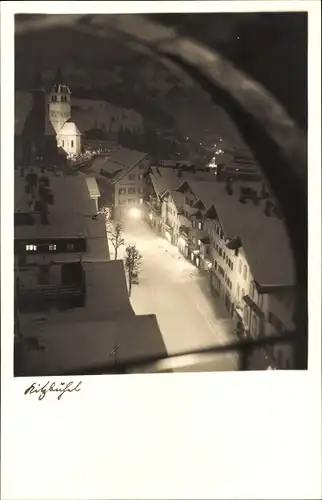 Ak Kitzbühel in Tirol, Durchblick auf Ort im Winter bei Nacht