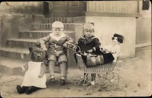 Foto Ak Junge und Mädchen mit Teddy und Puppe im Puppenwagen