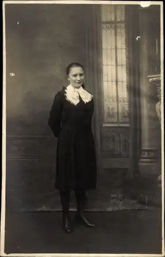 Foto Ak Standportrait einer jungen Frau im schwarzen Kleid