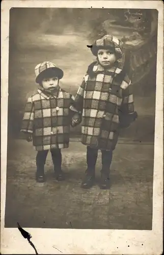 Foto Ak Zwei Kinder in karierten Wintermänteln, Portrait