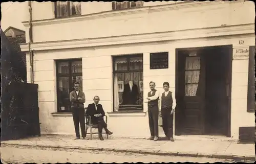 Foto Ak Männer vor einem Geschäft, H. Trede
