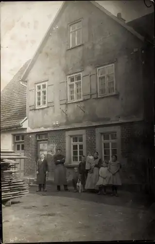 Foto Ak Familie vor einem Wohnhaus, Gruppenaufnahme