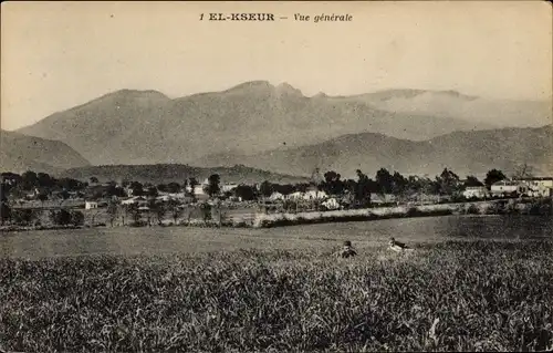 Ak El Kseur Algerier, Gesamtansicht, Blick von einem Feld zur Ortschaft, Berge