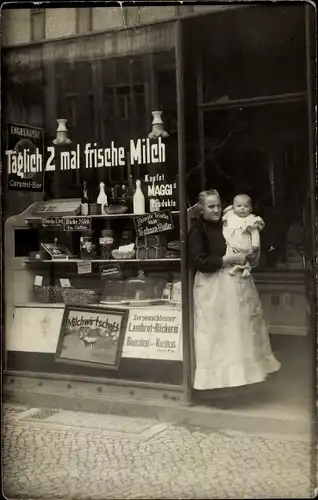 Foto Ak Berlin, Lebensmittelgeschäft, Milch, Schaufenster, Reklametafeln, Frau mit Baby