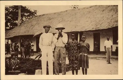 Ak Afrikanische Familie, Gruppenbild, Wohnhaus, Strohdach