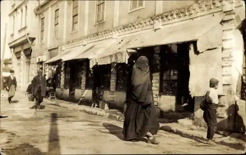 Foto Ak Verschleierte Frau, Straßenpartie, Kind, Geschäft