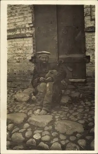 Foto Ak Russland ?, Mann vor einem Gebäude, Bettler ?
